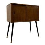 Load image into Gallery viewer, Mid-century modern wooden sideboard cabinet with two doors, black tapered legs, and brass-colored feet, shown on a plain white background.
