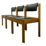 Load image into Gallery viewer, Three matching wooden dining chairs with black upholstered seats and backrests, arranged in a row against a plain white background.
