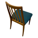 Load image into Gallery viewer, A mid-century modern wooden dining chair with a curved backrest, vertical slats, and a teal blue upholstered seat, shown from a high-angle rear view on a white background.
