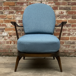 Load image into Gallery viewer, Blue armchair against a brick wall
