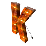 Load image into Gallery viewer, A 3D decorative letter 'K' marquee light with a textured orange and brown marble-like finish, illuminated with warm yellow lights inside. A black power cord is visible against a plain white background.
