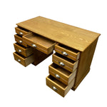 Load image into Gallery viewer, A wooden writing desk with multiple drawers, shown on a plain white background. The desk has a warm medium-brown wood finish with silver metal drawer pulls, and several drawers are pulled open to show storage space.
