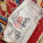 Load image into Gallery viewer, Textile tag with numbers on a multicolored woven fabric background
