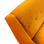 Load image into Gallery viewer, Close-up of a mustard yellow velvet armchair showing the tufted backrest and rounded armrest against a plain white background.
