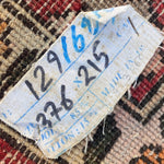 Load image into Gallery viewer, Textile tag with numbers on a patterned fabric background
