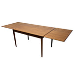 Load image into Gallery viewer, A mid-century modern extendable wooden dining table with a warm medium-brown finish and tapered legs, shown on a plain white background.

