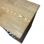 Load image into Gallery viewer, Close-up of a light oak wood tabletop showing the natural grain pattern, with a dark wood side panel and a small portion of a blue patterned base visible underneath, isolated on a white background.

