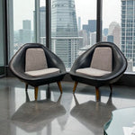 Load image into Gallery viewer, Two modern black chairs with gray cushions in front of a city skyline view.
