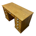 Load image into Gallery viewer, A mid-century wooden writing desk with a warm honey oak finish, featuring multiple drawers on both ends and polished silver metal drawer pulls, shown on a plain white background.
