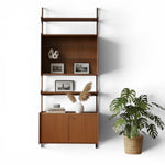 Load image into Gallery viewer, Wooden bookshelf with decorative items and a plant on a white background
