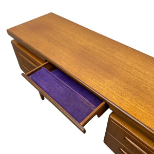 Wooden desk with an open purple drawer on a white background