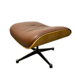 Load image into Gallery viewer, A mid-century modern lounge chair with a curved brown leather seat, a light wood shell, and a black metal four-star base, shown against a plain white background.
