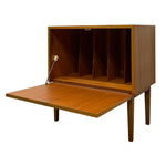 Load image into Gallery viewer, A mid-century modern wooden storage cabinet with a hinged front panel that is open, revealing a four-compartment interior and a small built-in desk surface.
