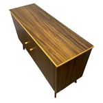 Load image into Gallery viewer, Mid-century modern sideboard cabinet with a dark brown wood grain finish, a thin gold metal trim accent along the top edge, and two small gold pull knobs, shown from an elevated perspective against a white background.
