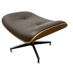 Load image into Gallery viewer, Mid-century modern lounge chair with a dark brown leather cushion, a curved wood veneer side panel, and a black metal star base with silver casters, shown on a plain white background.
