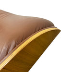 Load image into Gallery viewer, Close-up detail of a mid-century modern lounge chair, showing a brown leather seat cushion and a curved wooden shell with a light wood veneer edge, isolated on a white background.
