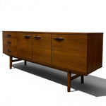 Load image into Gallery viewer, Mid-century modern wooden sideboard with a warm medium-brown walnut finish, featuring five drawers on the left and three larger cabinet doors on the right, each with matching dark wood handles, supported by angled legs on a white background.
