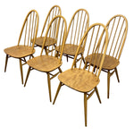 Load image into Gallery viewer, Six wooden spindle-back dining chairs with a natural oak finish, arranged in two rows against a plain white background.
