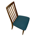 Load image into Gallery viewer, A mid-century modern wooden dining chair with a warm brown wood frame and a teal blue upholstered seat cushion, shown against a plain white background.

