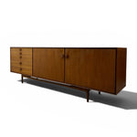 Load image into Gallery viewer, Mid-century modern wooden sideboard cabinet with a warm medium-brown wood finish, featuring three drawer sections on the left and two cabinet doors on the right, supported by tapered metal legs, shown on a white background with a soft shadow.

