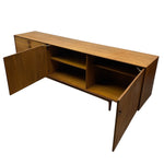 Load image into Gallery viewer, Mid-century modern wooden sideboard with a warm medium-brown finish, featuring open cabinet doors, two interior shelves, and a clean white background.
