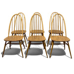 Load image into Gallery viewer, Six wooden dining chairs with curved spindle-back designs, shown in a set of three pairs on a white background.
