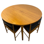 Load image into Gallery viewer, CIRCULAR DINING TABLE WITH DINING CHAIRS IN BLACK VINYL ON A WHITE BACKGROUND
