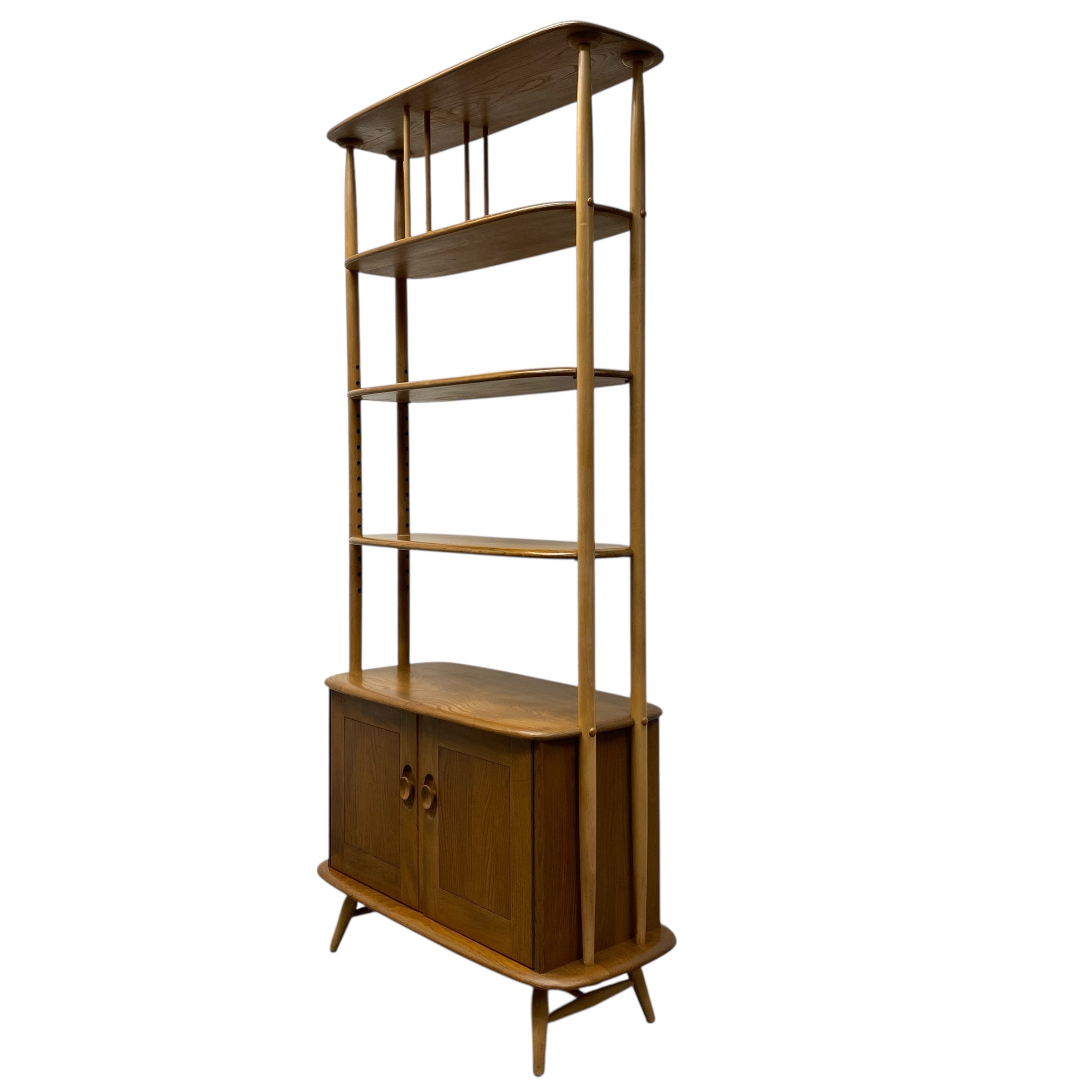 Wooden Ercol bookshelf with multiple shelves on a white background