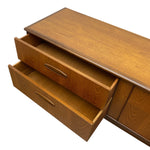 Load image into Gallery viewer, A mid-century modern wooden sideboard or credenza with two open drawers, showcasing a warm medium-brown wood grain finish and brass drawer pulls, isolated on a white background.
