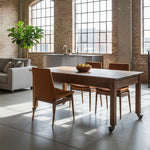 Load image into Gallery viewer, Dining area with wooden table and chairs in a room with large windows and brick walls.
