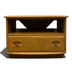 Load image into Gallery viewer, A mid-century modern wooden TV stand or console table with a warm honey oak finish, featuring two oval drawer fronts and an open shelf with triangular cutouts.
