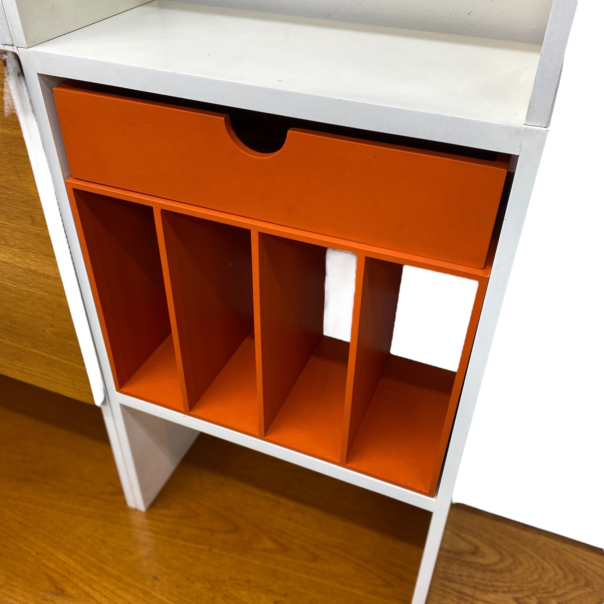 White shelf with orange storage FILES on a wooden floor