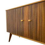 Load image into Gallery viewer, Mid-century modern wooden sideboard cabinet with two doors, vertical wood grain panels, round light wood knobs, and tapered wooden legs, shown on a white background.
