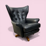 Load image into Gallery viewer, Black leather armchair on a pink background
