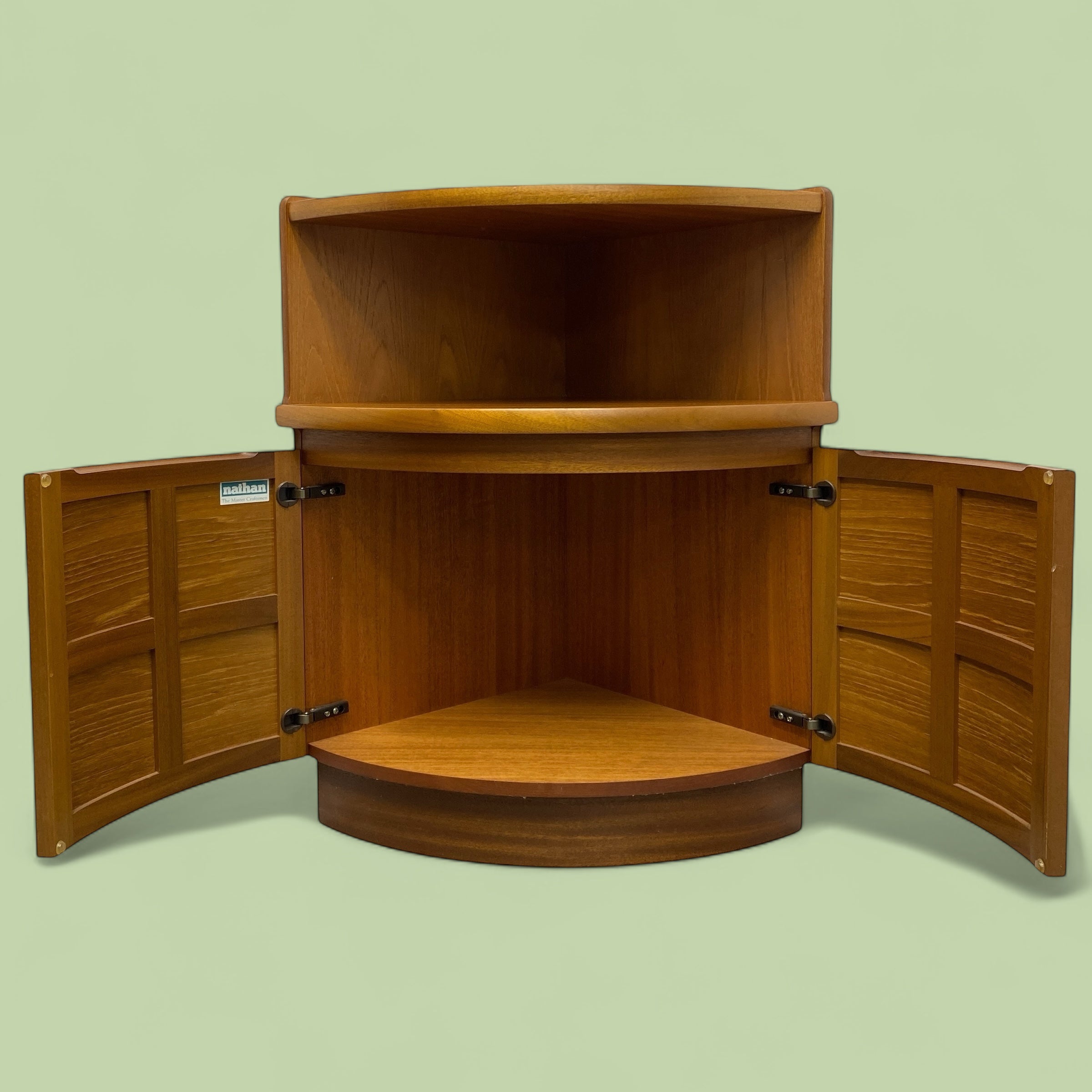 Wooden corner cabinet with open doors on a light green background