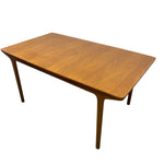 Load image into Gallery viewer, A mid-century modern wooden dining table with a warm medium-brown finish, featuring a rectangular top with rounded corners and tapered legs, shown on a plain white background.
