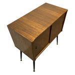 Load image into Gallery viewer, Mid-century modern wooden sideboard cabinet with a warm brown wood grain finish, tapered black legs, and small brass hardware, shown on a plain white background.
