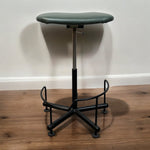 Load image into Gallery viewer, Green stool with a black metal base on a wooden floor against a white wall
