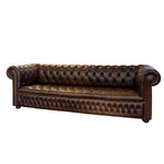 Load image into Gallery viewer, A classic brown leather Chesterfield sofa with deep button tufting, rolled arms, and nailhead trim, shown against a plain white background.
