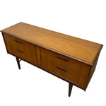 Load image into Gallery viewer, Mid-century modern wooden sideboard with a warm medium-brown wood grain finish, featuring two drawers on each end and a central cabinet door, supported by tapered legs.
