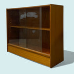 Load image into Gallery viewer, Wooden display cabinet with glass front on a light blue background
