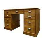 Load image into Gallery viewer, A mid-century modern wooden writing desk with a warm medium-brown finish, featuring multiple drawers on both sides and polished brass drawer pulls, shown on a solid white background.
