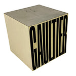 Load image into Gallery viewer, A square metallic table or stool with a brushed silver top and sides, featuring the word 'GAULTIER' in large black letters on the front, shown on a plain white background.
