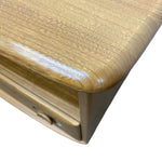 Load image into Gallery viewer, Close-up of a wooden furniture corner showing a smooth, rounded top surface and a drawer with a round knob, on a plain white background.
