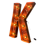 Load image into Gallery viewer, A large illuminated marquee letter 'K' light sign with an orange and brown marble pattern, featuring multiple warm yellow light bulbs set inside. A small black remote control is shown to the right of the letter on a plain white background.
