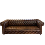 Load image into Gallery viewer, A classic brown leather Chesterfield sofa with deep button tufting, rolled arms, and nailhead trim, shown against a plain white background.
