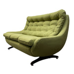 Load image into Gallery viewer, A mid-century modern lounge chair upholstered in olive green fabric with a tufted backrest and curved armrests, supported by a black metal swivel base, shown against a plain white background.
