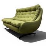 Load image into Gallery viewer, A mid-century modern upholstered lounge chair in olive green fabric with a tufted backrest and curved arms, supported by a black swivel base, shown on a white background with a soft shadow.
