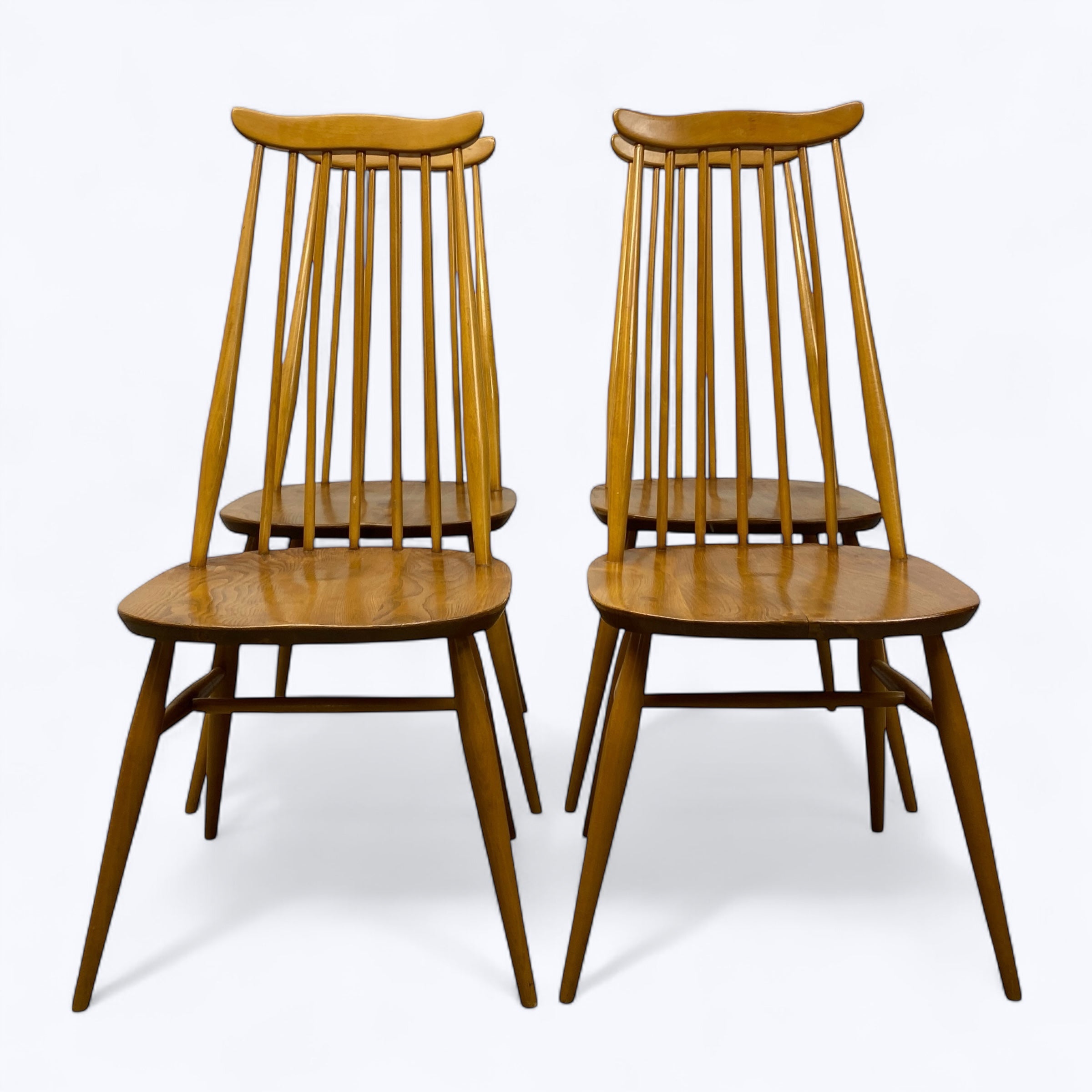 Two wooden chairs with spindle backs on a white background