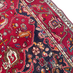 Load image into Gallery viewer, Close-up of a patterned rug with intricate designs on a red background
